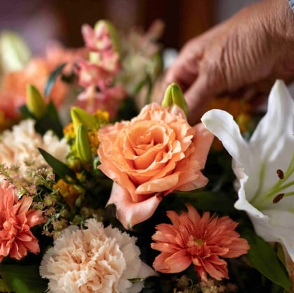 Hands arranging flowers creating a meaningful and supportive setting for funeral homes Frisco, TX.