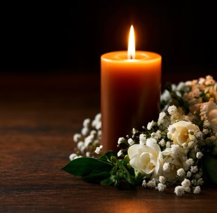 Memorial candle and white flowers representing funeral homes in Little Elm, TX.