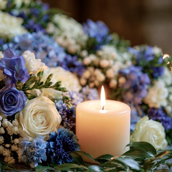 Memorial candle surrounded by flowers in Prosper, TX.